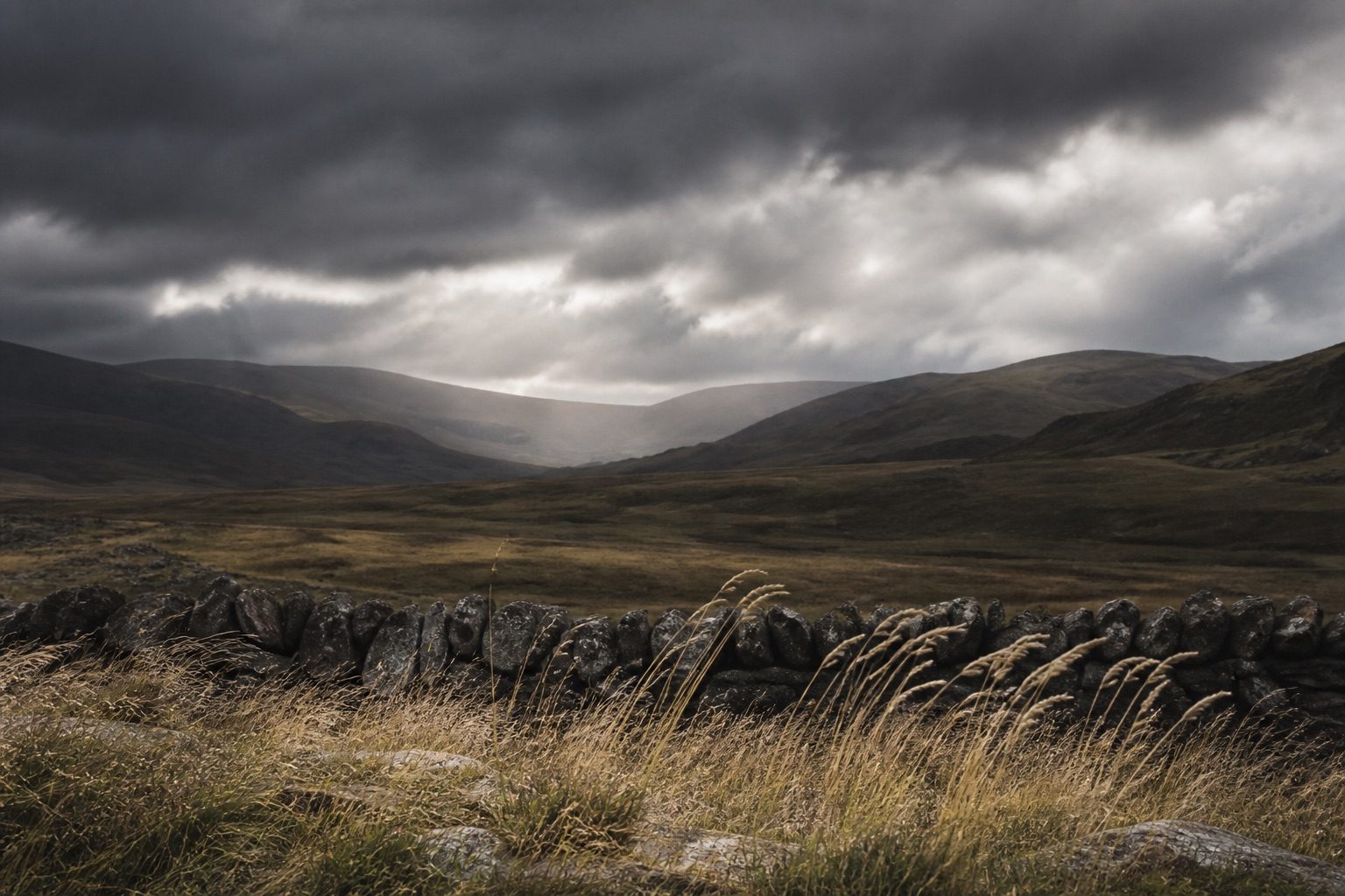 Generic Scottish Highland landscape beneath dramatic clouds.